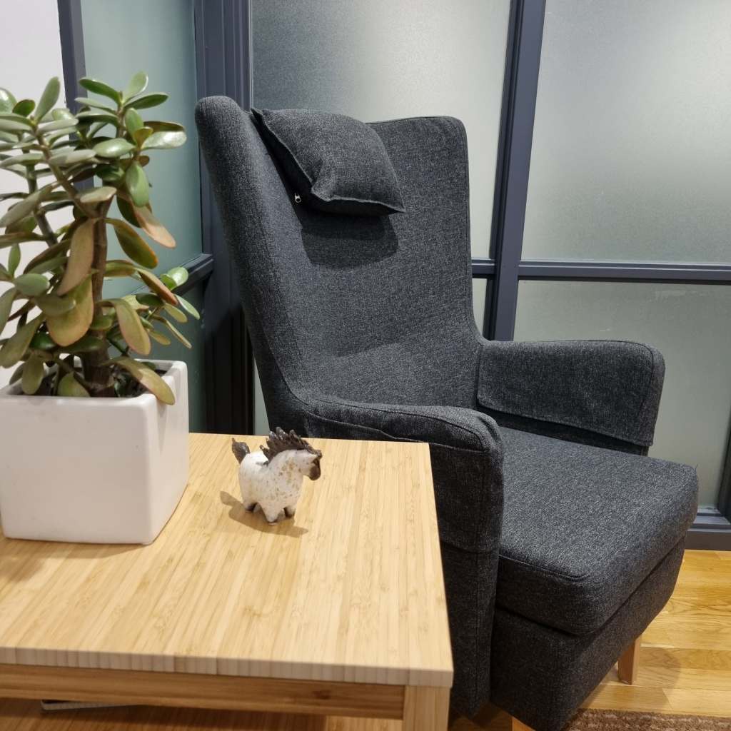 En bekväma stolar, i förgrunden ett avställningsbord med en planta och en liten porslinshäst